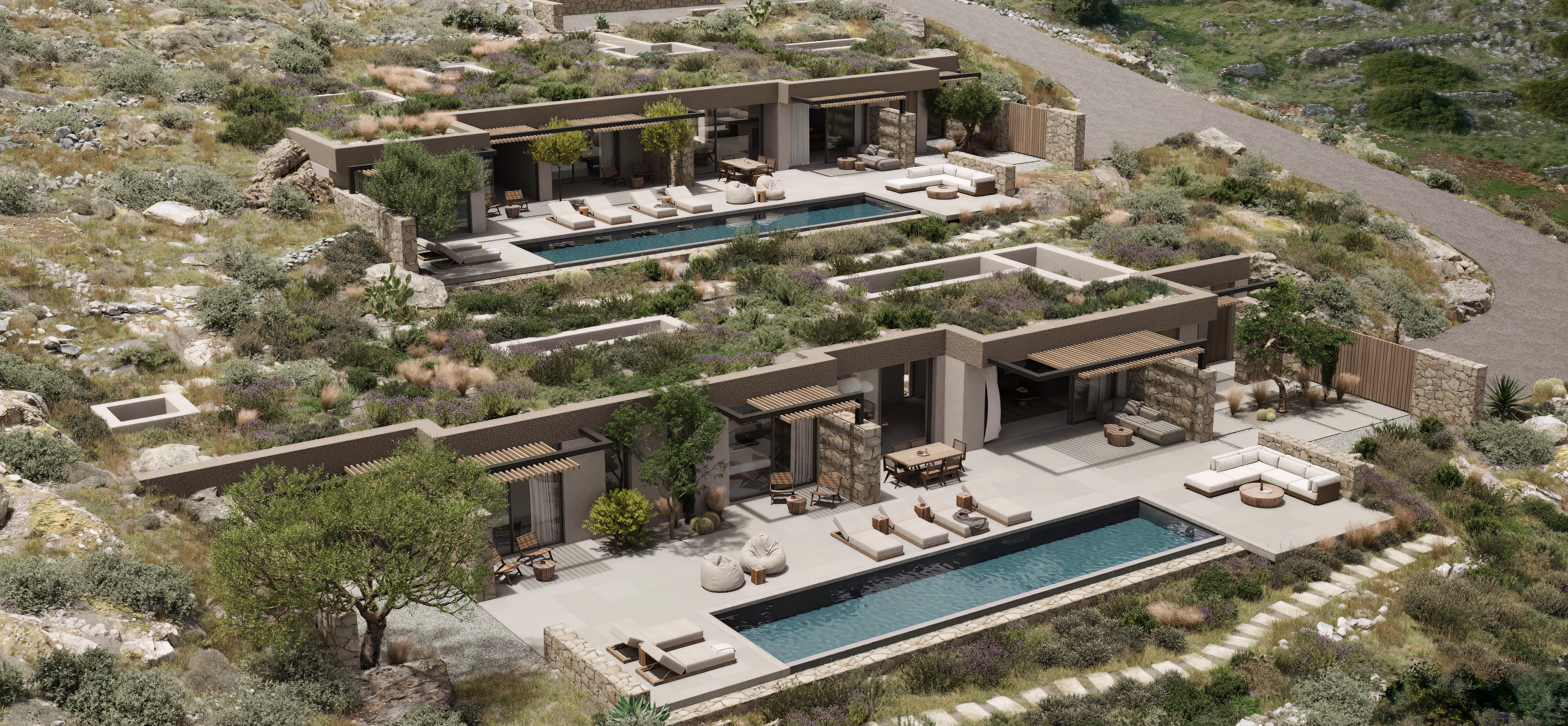 Aerial view of two matching single-story villas with lap pools and stone-walled terraces, connected by a gravel driveway winding through a rocky hillside.