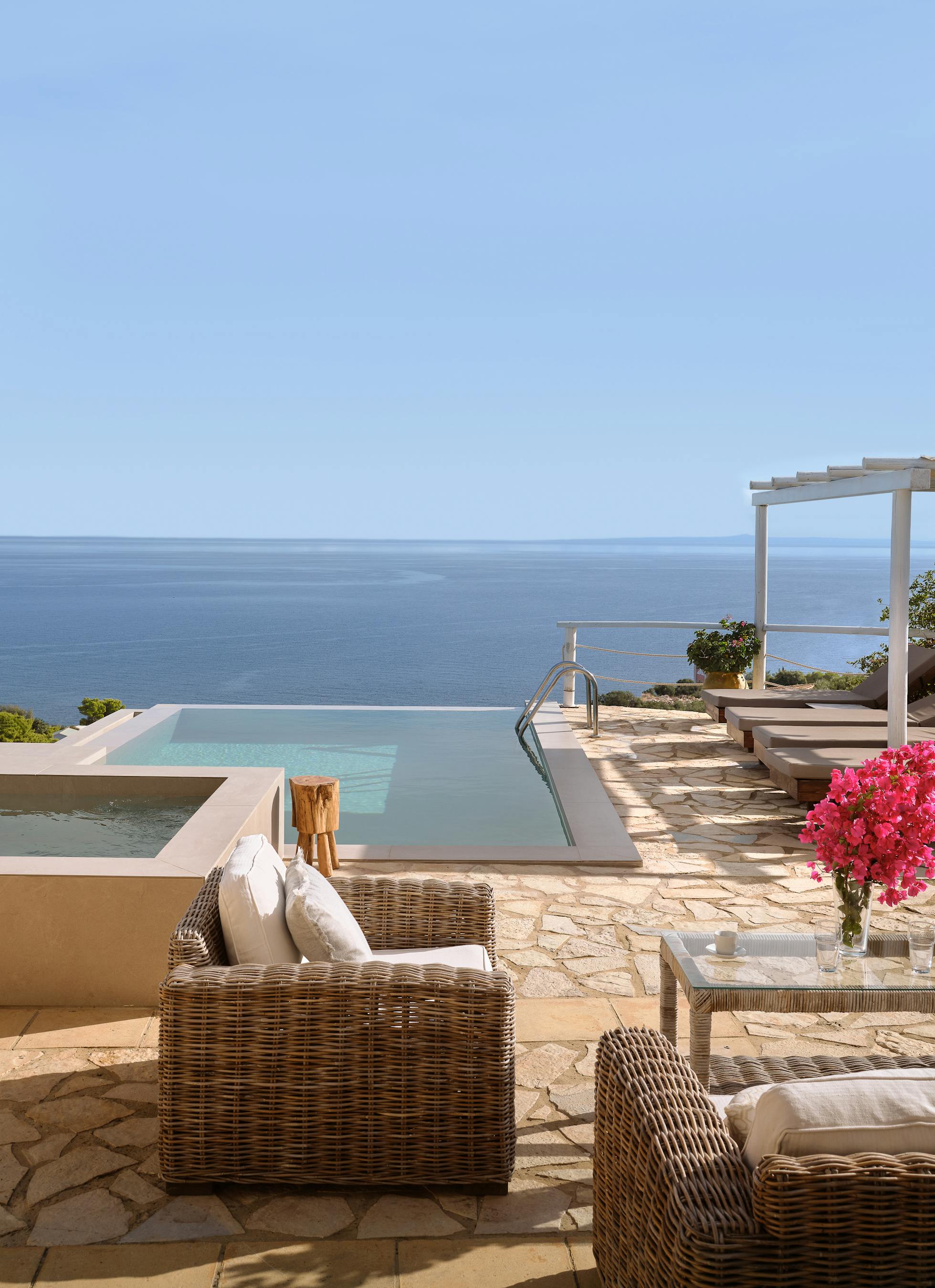 Luxury infinity pool terrace with wicker lounge furniture, hot tub, and panoramic Mediterranean Sea views.