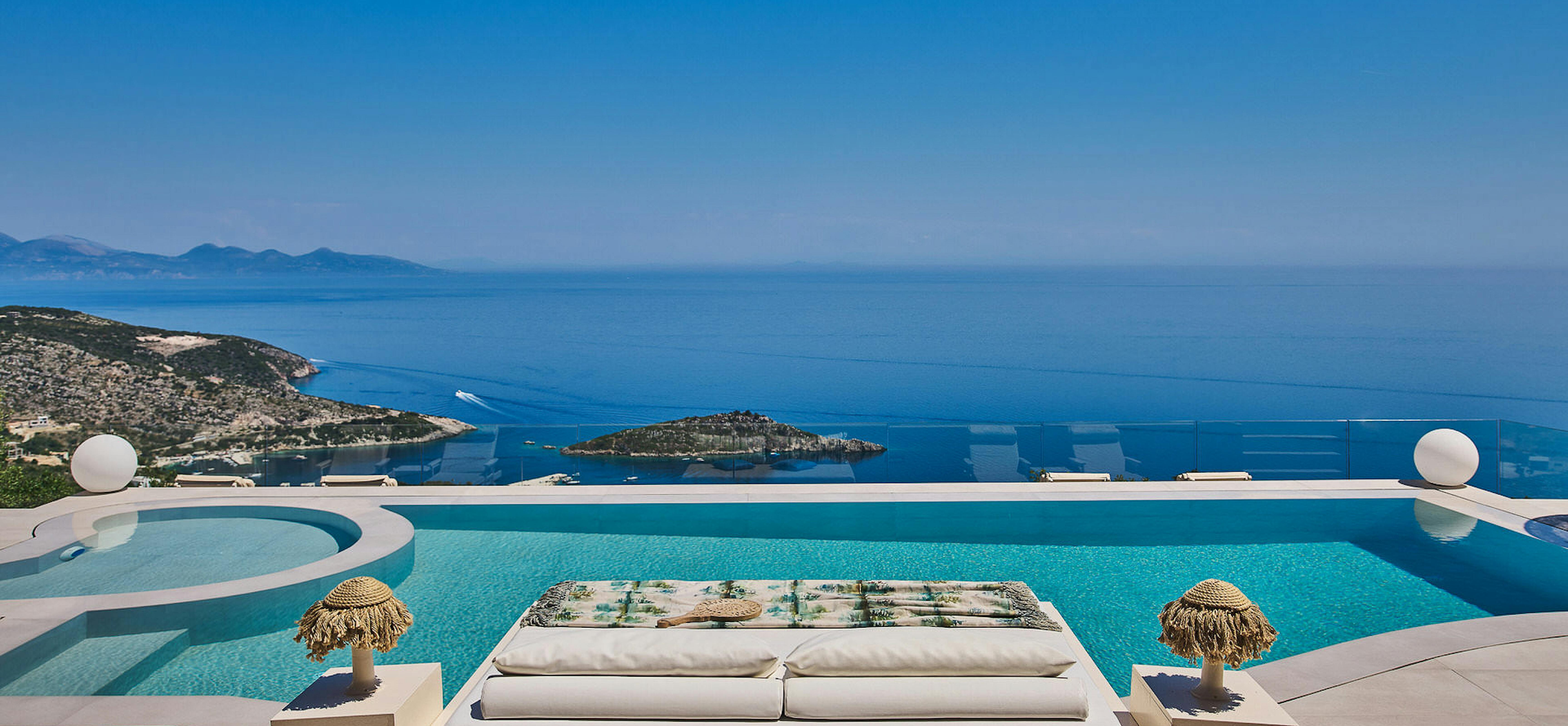 Minimalist infinity pool with floating daybed platform and seamless ocean horizon views.