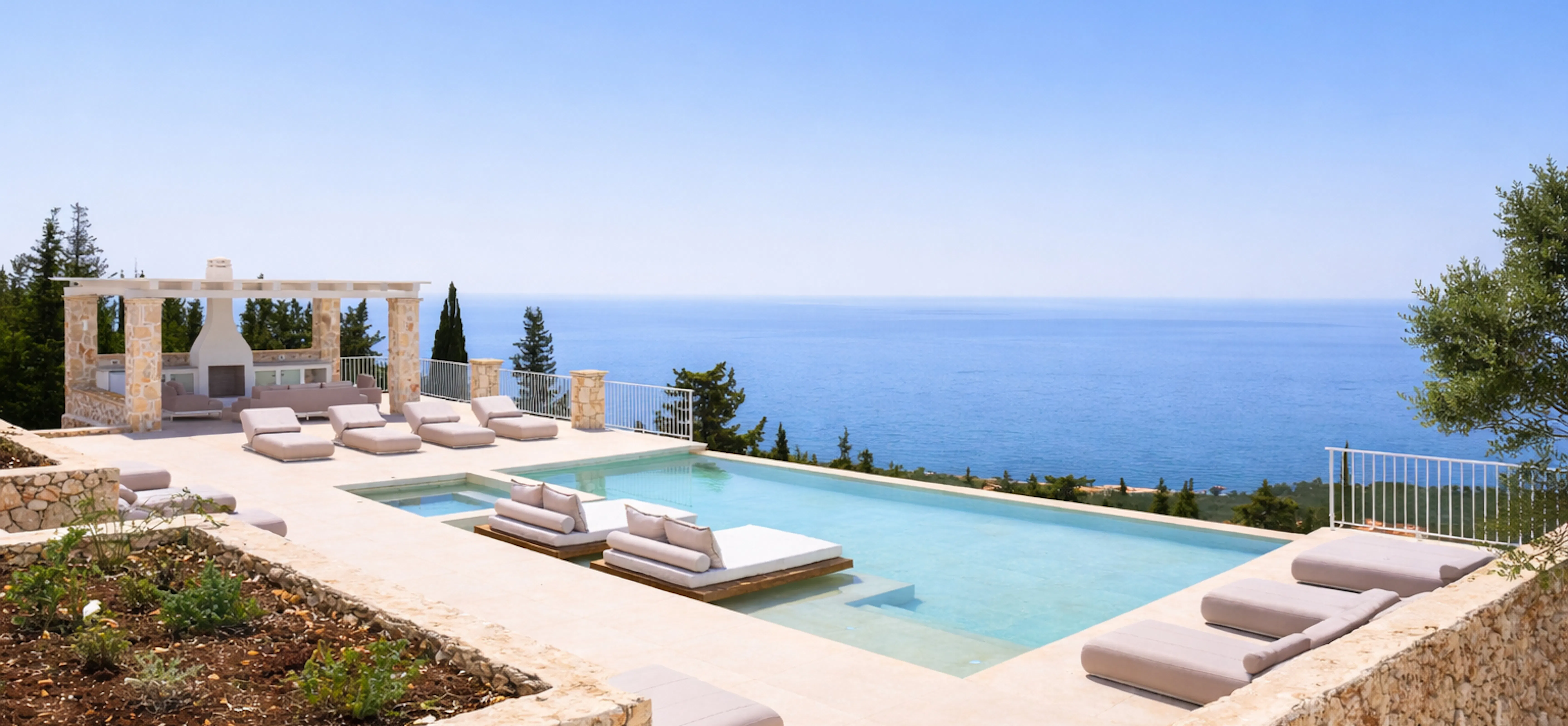 A spectacular pool overlooking the Mediterranean Sea features plush neutral loungers and a separate spa pool. The clifftop terrace includes a stone pergola structure with panoramic ocean views stretching to the horizon.